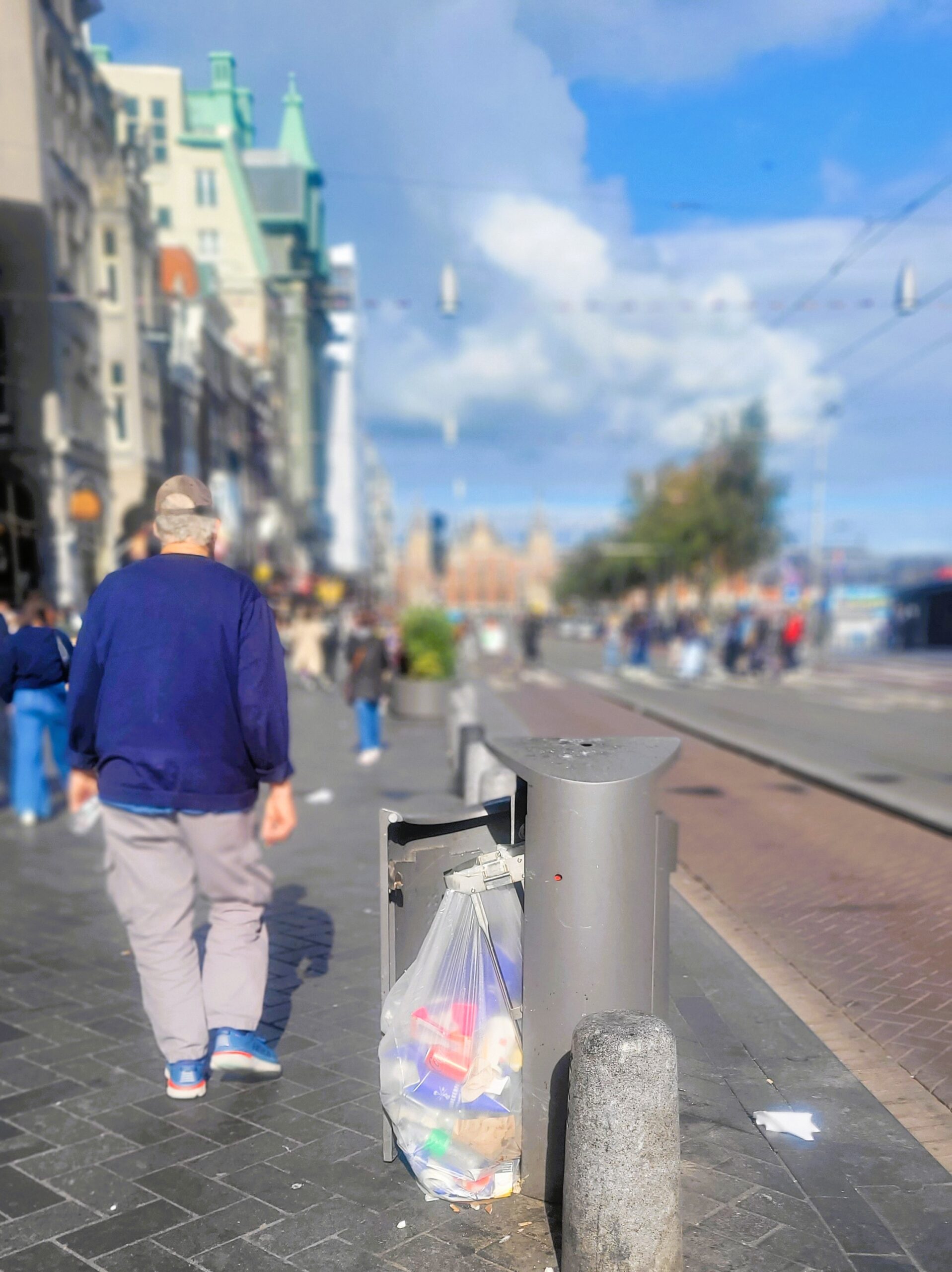 Pemandangan tempat sampah yang dibuka paksa oleh pemulung dengan latar belakang Stasiun Sentral Amsterdam dan jalan Damrak, daerah turis yang sibuk (Foto: Hengky Kurniawan)