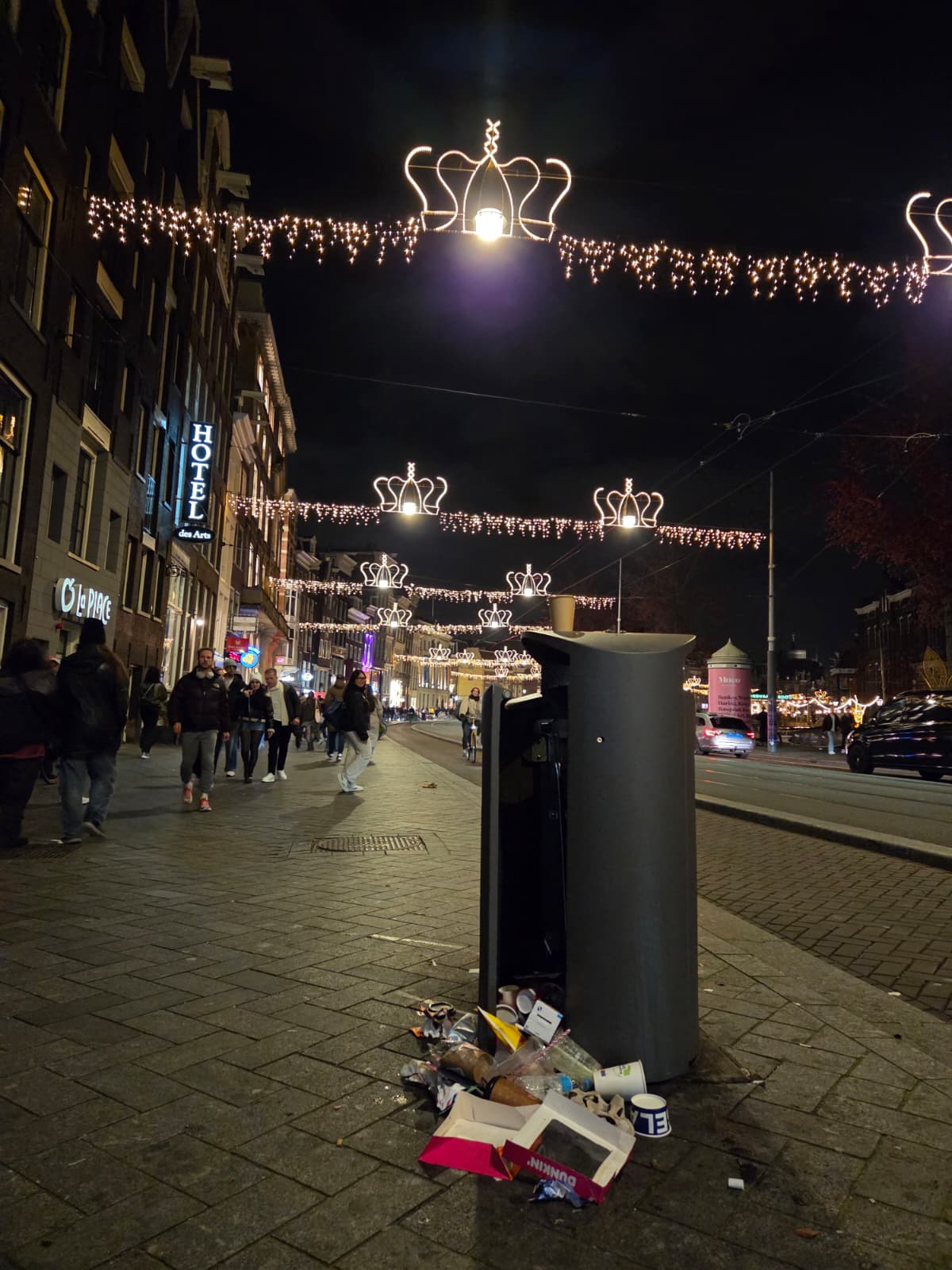 Pemandangan tempat sampah yang dibuka paksa oleh pemulung dengan latar belakang Stasiun Sentral Amsterdam dan jalan Damrak, daerah turis yang sibuk (Foto: Hengky Kurniawan)